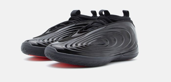 Μαύρα φουτουριστικά sneakers χαμηλού τύπου με κυματιστή υφή και θηλιές στο γλώσσα και στην φτέρνα, τοποθετημένα σε λευκό φόντο.