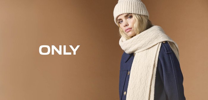Beige geribde gebreide muts en sjaal gecombineerd met een donkerblauwe jas met gouden knopen en zijzakken. Tekst luidt "ONLY."