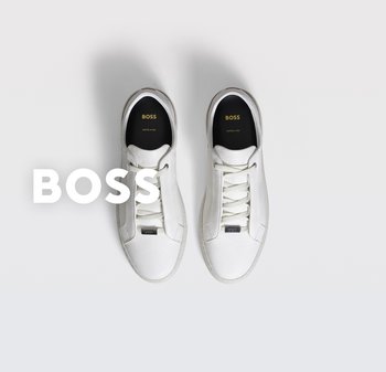 Zapatillas deportivas de cuero blanco con acabado texturizado, cordones planos, forro negro y detalle del logotipo en relieve en la lengüeta. Diseño minimalista.