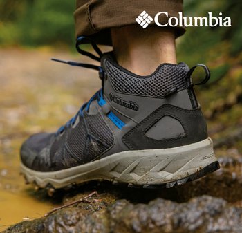 Botte de randonnée imperméable Columbia, grise avec des accents noirs et des détails bleus, dotée d'un dessus en maille texturée et d'une semelle robuste pour une bonne traction.