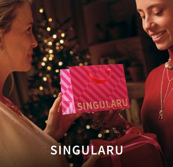 Heldere roze boodschappentas met een gestreept patroon en een rood handvat, met de tekst "SINGULARU" in het wit. Cadeaubox met roze lint vlakbij.