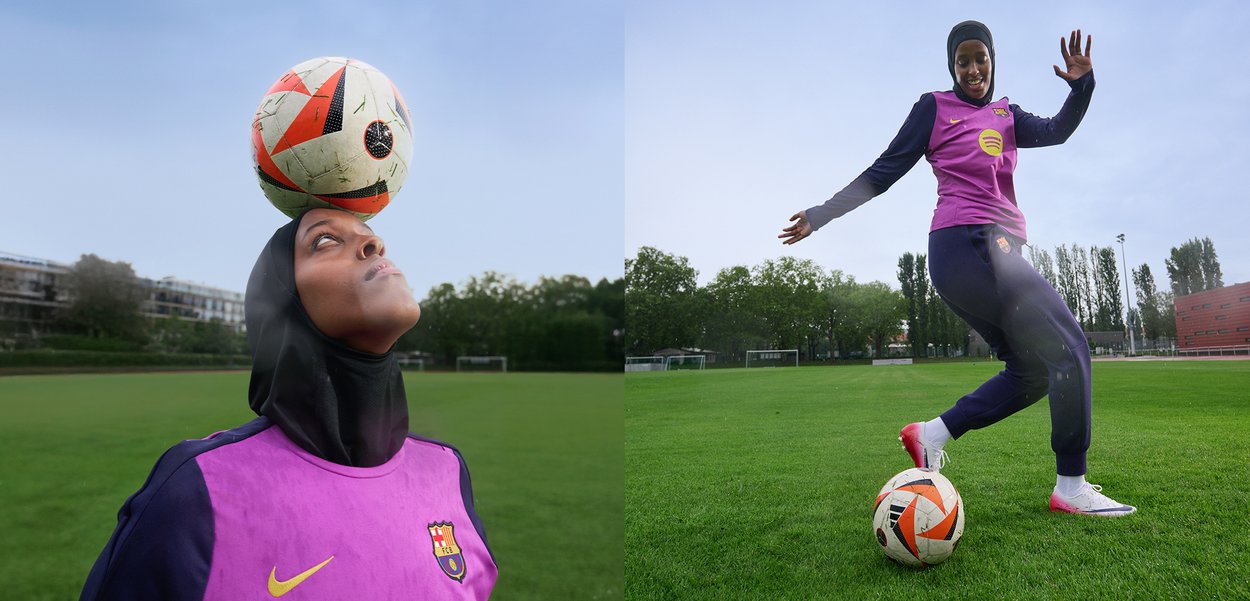 Un calciatore bilancia un pallone a quadri sulla testa, indossando una maglietta viola con un logo e pantaloni neri, mentre esegue un calcio sull'erba.