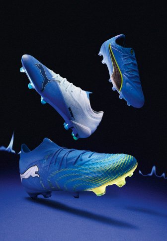 Три сини и бели футболни обувки Puma с неоново жълти акценти, показани на тъмен фон.