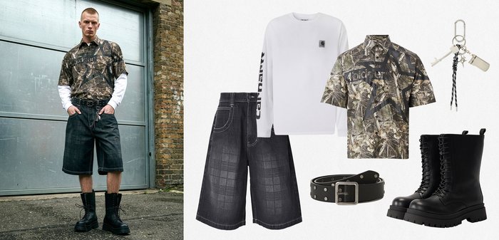 Homme portant une chemise à manches courtes camouflage sur un t-shirt blanc à manches longues, un short large noir, une ceinture noire et des bottes de combat noires à lacets, debout en plein air.