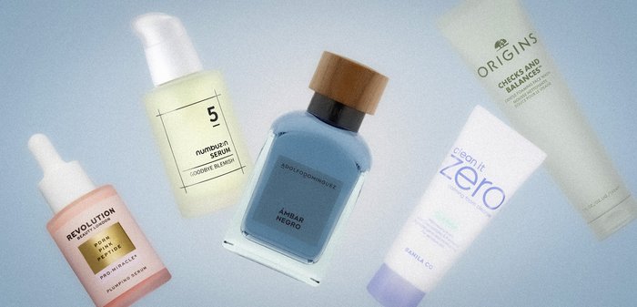 Cinq flacons de soins de la peau et de parfum disposés sur une surface claire, comprenant des sérums, un nettoyant et un parfum bleu avec un bouchon en bois.