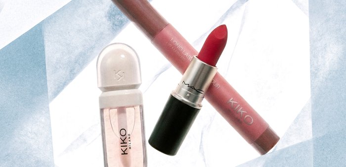 Flacon de parfum KIKO Milano, rouge à lèvres MAC rouge avec le capuchon enlevé, et crayon contour des lèvres longue tenue KIKO sur une surface en marbre blanc.