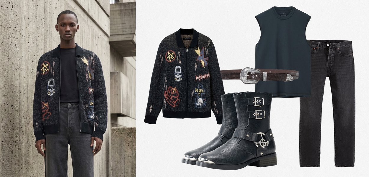 Mies, joka pukeutunut mustaan graafiseen bombaripukuun, mustaan pyöreäkaulaiseen t-paitaan, tummanharmaisiin farkkuihin; mukana mustat nahkasaappaat ja ruskea vyö.