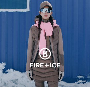 Brązowa kurtka puchowa z kapturem, nałożona na brązową sukienkę. Różowy szalik związany wokół szyi, szare rękawiczki i czapka. Śnieżne tło.