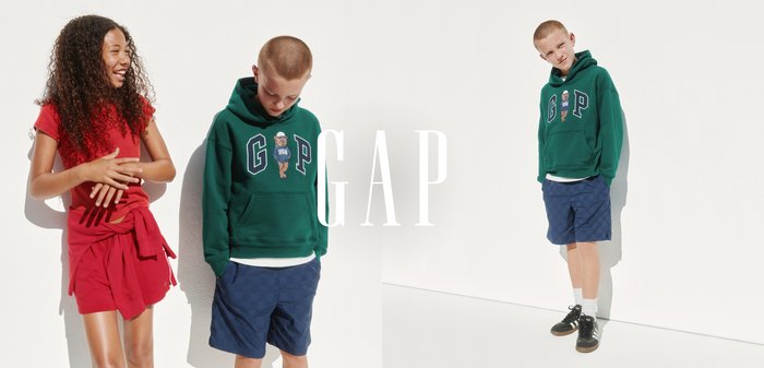 To børn iført casual tøj fra GAP; en pige i røde shorts og t-shirt, og en dreng i en grøn hættetrøje med navy shorts.