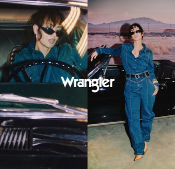 Denim jumpsuit i mørk blå med kontrasterende sømmer, belte i midjen, accessorert med solbriller, mot en bakgrunn av en vintagebil.
