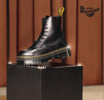 Zwarte leren enkellaars met ronde neus, gele stiksels en een grove, getextureerde zool. Heeft veters en een treklipje met het merklogo.