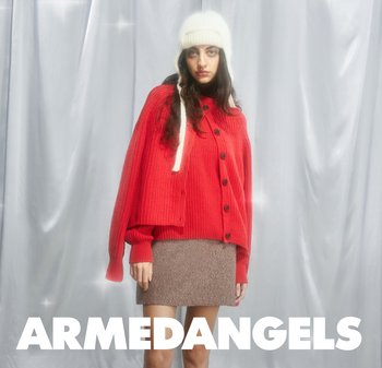 Red knitted cardigan with button closure, paired with a brown mini skirt. A white knit hat with ear flaps completes the outfit.