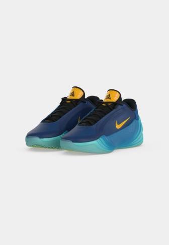 Чифт тъмносини маратонки Nike с жълти знаци Swoosh и аквамаринови подметки на изчистен светъл фон.