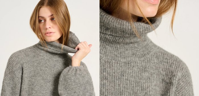 Grå stickad polotröja med ribbad struktur och ballongärmar, med hög krage och relaxed passform.