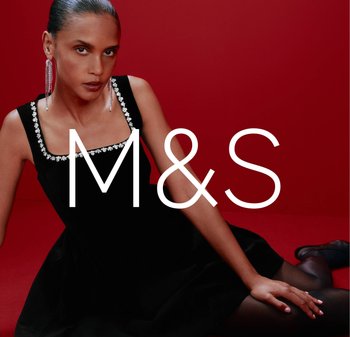 Black velvet dress with a square neckline and jeweled trim, paired with dangly earrings, set against a red background.