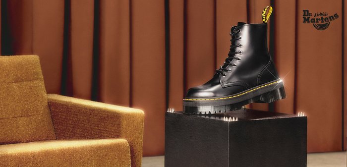 Stivaletto alla caviglia in pelle nera con punta rotonda, cuciture gialle e suola spessa e testurizzata. Presenta lacci e linguetta posteriore con logo del marchio.