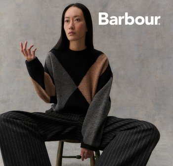 Knit sweater featuring a geometric pattern in black, gray, and beige. Loose fit with wide sleeves, paired with pinstriped trousers.