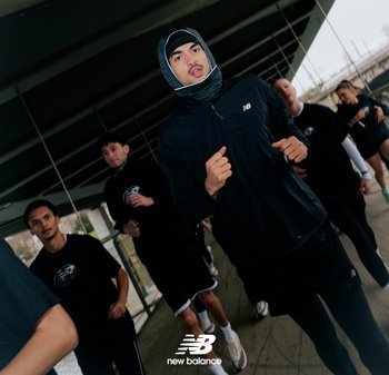 Black athletic jacket and shorts worn by runners. Fabric appears lightweight. Group jogs under a concrete structure, some wearing hoodies.