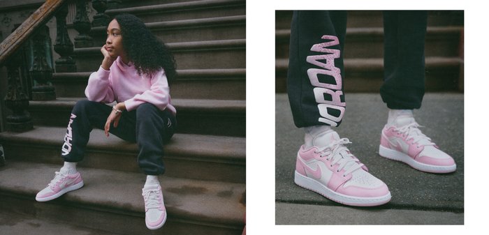 Hanorac roz, pantaloni de trening negri cu litere albe și adidași roz de la Nike. Modelul pozează pe trepte cu părul creț și o expresie gânditoare.