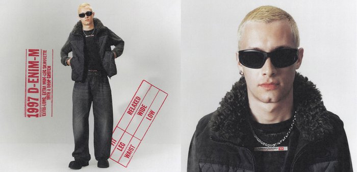 Person trägt schwarze Sonnenbrille, schwarze Jacke mit Pelzkragen, weite schwarze Jeans, steht mit Händen in den Taschen vor einfarbigem Hintergrund.
