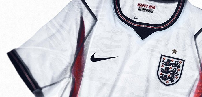 Maillot de football blanc de l’Angleterre avec des bordures bleu marine et rouge, logo Nike, blason aux trois lions, et texte « Happy and Glorious » à l’intérieur du col.