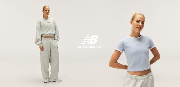 Sweat-shirt gris court et pantalon de survêtement assorti, avec détails de logo. Haut à manches courtes bleu clair, tous deux avec des textures douces et une coupe décontractée.