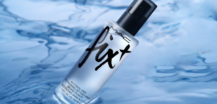 MAC Fix, un flacone spray in vetro trasparente con un tappo a pompa nero, presenta un testo nero audace sul fronte, evidenziando la sua formula senza alcool.