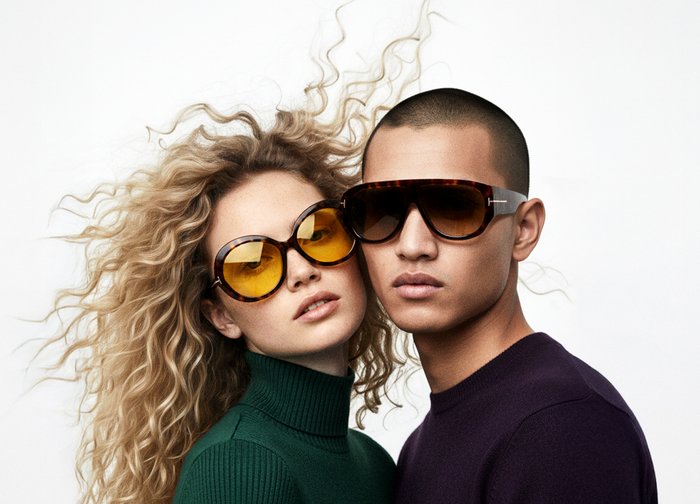 Kerek napszemüveg sárga színű lencsékkel és teknősbéka mintás kerettel. Az egyik modell zöld garbót visel, míg a másik sötét pulóvert.