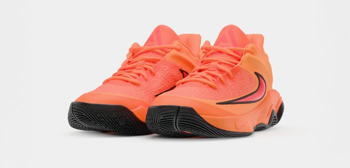 Φωτεινά πορτοκαλί αθλητικά παπούτσια με μαύρες υφασμάτινες σόλες και μαύρο λογότυπο swoosh στα πλευρά, τοποθετημένα σε λευκό φόντο.