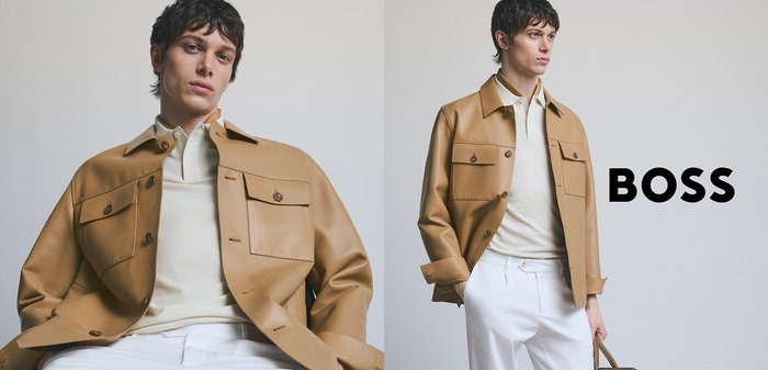 Tan Lederjacke mit zwei Fronttaschen, getragen über einem hellen cremefarbenen Hemd, kombiniert mit weißen Hosen. Der Hintergrund ist neutral.