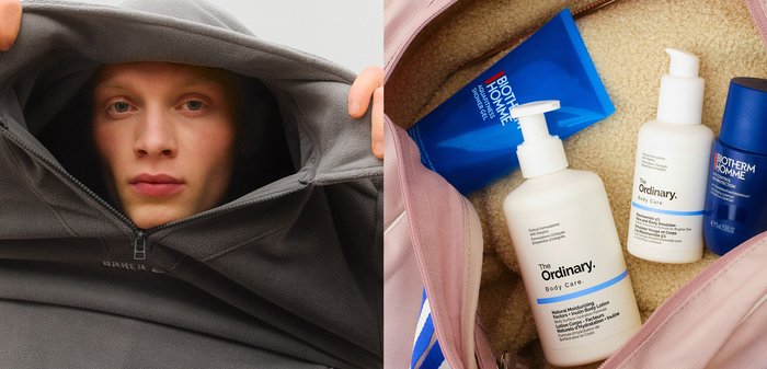 Sweat à capuche gris en polaire avec une grande capuche et une fermeture éclair en focus, aux côtés d'un sac rose contenant des produits de soins de la peau de différentes formes et couleurs.
