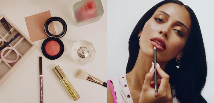 Femme aux cheveux foncés appliquant un crayon à lèvres mauve, portant des boucles d'oreilles en forme d'étoile et un haut clair avec des œillets.