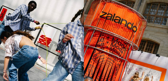 Des jeunes sautent à la corde à l'extérieur près d'une vitrine Zalando orange vif avec du texte et une grande fresque murale.