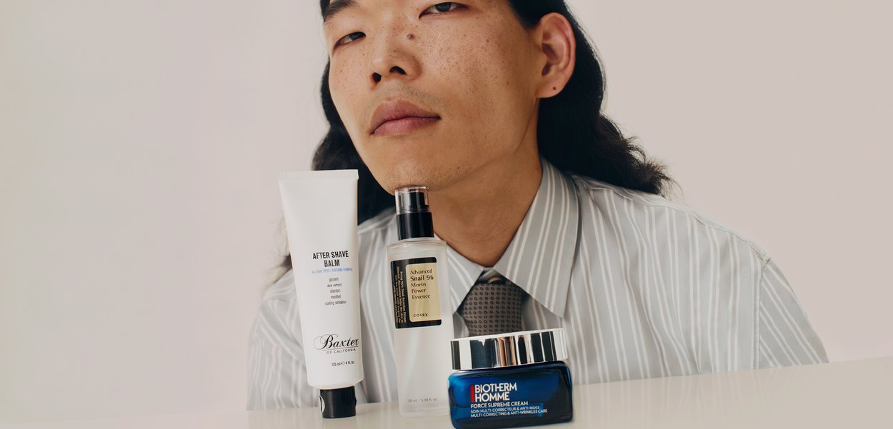 Drei Hautpflegeprodukte, die auf einer weißen Oberfläche angeordnet sind: eine weiße Tube After Shave Balm, eine transparente Flasche Advanced Snail Essence und ein blauer Tiegel Force Supreme Cream.