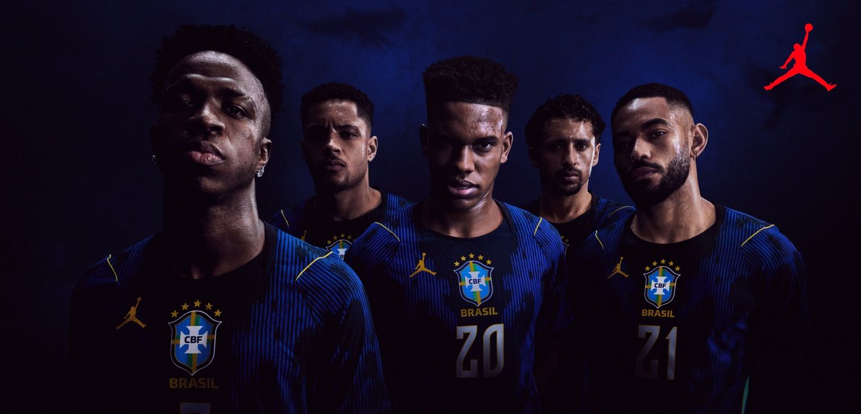 Fünf männliche brasilianische Fußballspieler in dunkelblauen Trikots mit CBF-Logos stehen eng beieinander vor einem dunklen Hintergrund, darüber ein rotes Jordan-Logo.