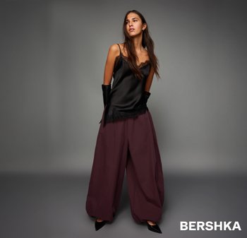 Černý saténový kamizol s krajkovým lemem, kombinovaný s vínovými širokými kalhotami. Nosit s černými rukavicemi a lodičkami s špičatou špičkou.