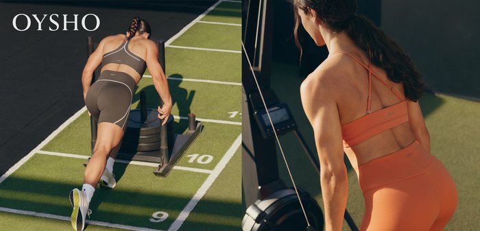 Athlete in sportswear pushing a weighted sled forward on a marked outdoor fitness track in bright daylight.