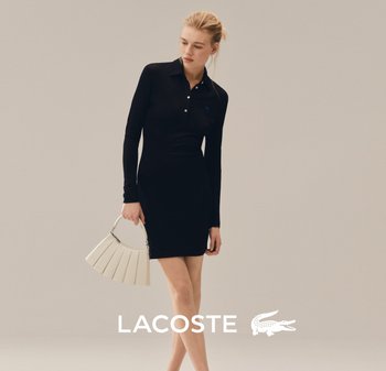 Mujer con un vestido tipo polo negro de manga larga sosteniendo un bolso blanco en forma de abanico, de pie frente a un fondo beige liso.