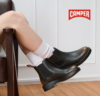 Schwarze Lederstiefel mit elastischen Seiten und einer Zuglasche, die einen braunfarbigen Akzent an der Zehe und eine strukturierte Gummisohle aufweisen.