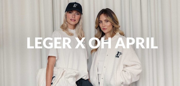 Due modelli indossano abbigliamento casual; uno indossa una maglietta beige e un cappellino nero, l'altro una giacca in pile bianca con un logo e pantaloni grigi.