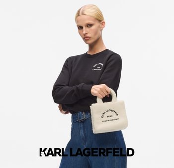 White faux fur handbag with a structured shape, featuring black printed text. Model wears a black sweatshirt and blue high-waisted jeans.