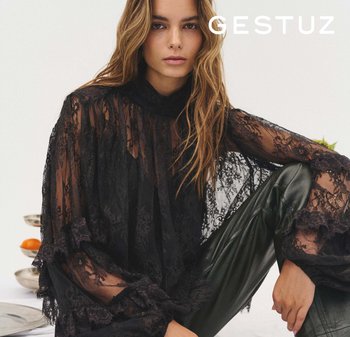 Crna bluza od čipke s naboranim rukavima i visokim okovratnikom, uparena s pripijenim crnim kožnim hlačama. Ovaj je izgled prozračan.