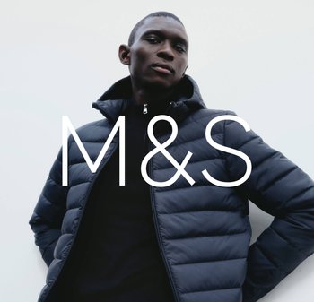 Mężczyzna w granatowej kurtce puchowej z kapturem, stojący na jednolitym jasnym tle, z nałożonym logo M&S.