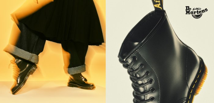 Schwarze Leder-Stiefeletten mit gelber Naht, Schnürung vorne und klobiger Sohle; sie verfügen über eine Zuglasche und dezente, strukturierte Details.