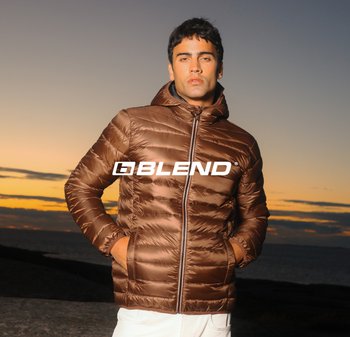 Braune Steppjacke mit Kapuze, mit gesteppter Textur und einem Reißverschluss vorne. Markenlogo gut sichtbar auf der Brust platziert.