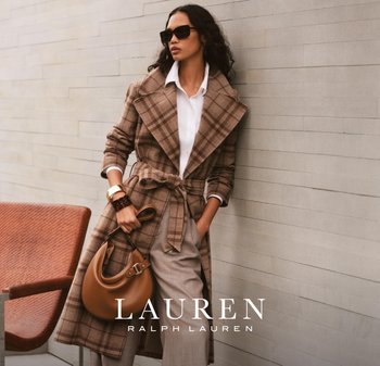 Trench coat a quadri marroni con ampio colletto, vita abbinata, indossato sopra una camicia bianca. Abbinato a pantaloni grigi e una borsa marrone. Occhiali da sole neri.