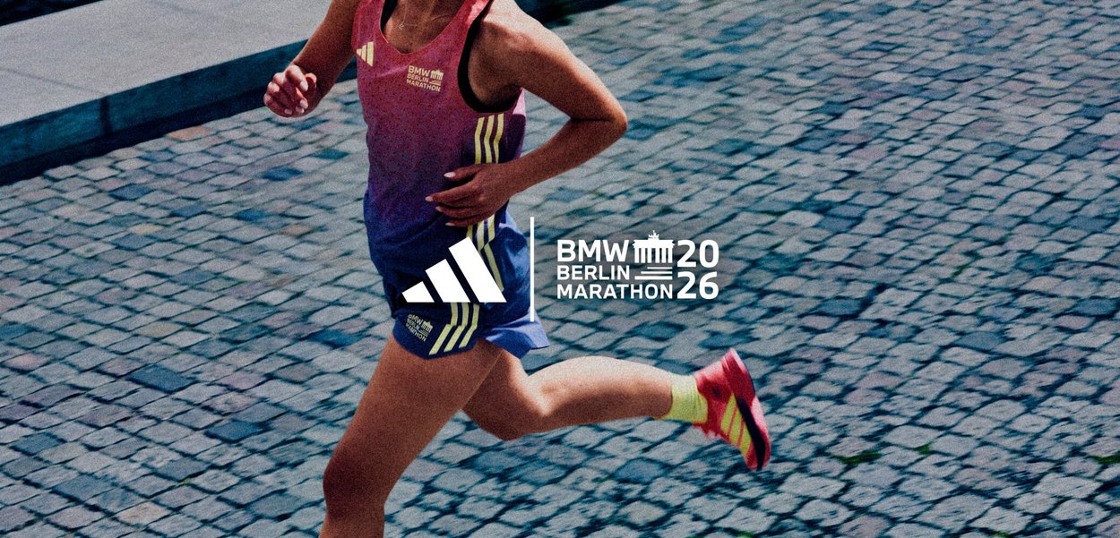 Runner wearing a pink and blue outfit with yellow shoes on a cobblestone street during the 2026 BMW Berlin Marathon.