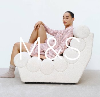 White textured sofa with round accents, angled back, and a smooth base. Model in pink check pattern sits casually, displaying contemporary design.