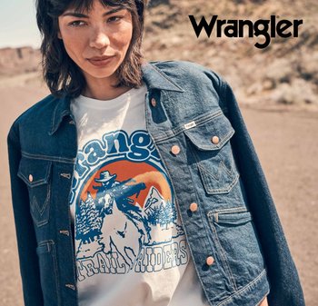 Jeansjacka med kopparknappar över en vit t-shirt med grafiskt tryck som visar en cowboy och berg, accentuerad av blå och orange färger.