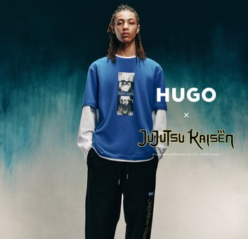 Camiseta azul de manga corta superpuesta sobre una camisa blanca de manga larga con un estampado gráfico. Pantalones negros con detalles en azul. Incluye logotipos de la marca.